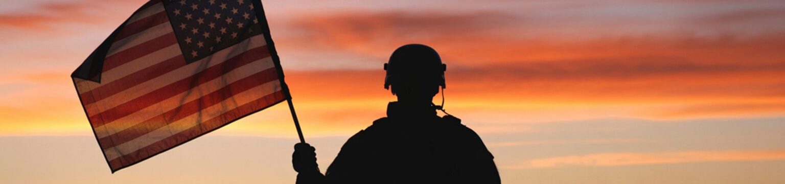 Veteran Holding Flag at Sunset