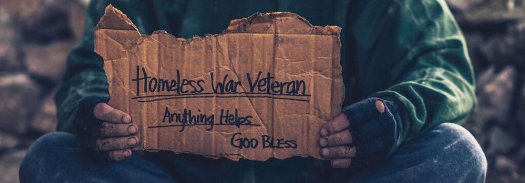Homeless Veteran Holding a Cardboard Sign with Homeless War Veteran Anything Helps God Bless Text
