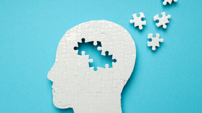 White Human Head Puzzle on Blue Background with Brain Puzzle Pieces Missing