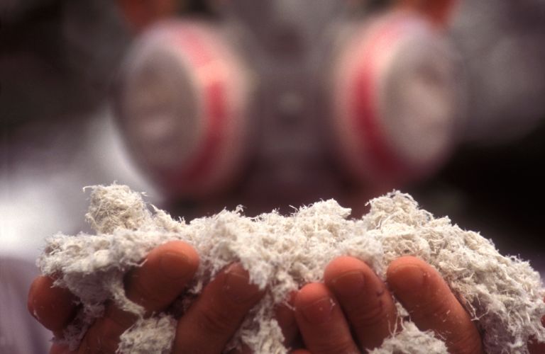 Man In Respirator Holding Asbestos Materials
