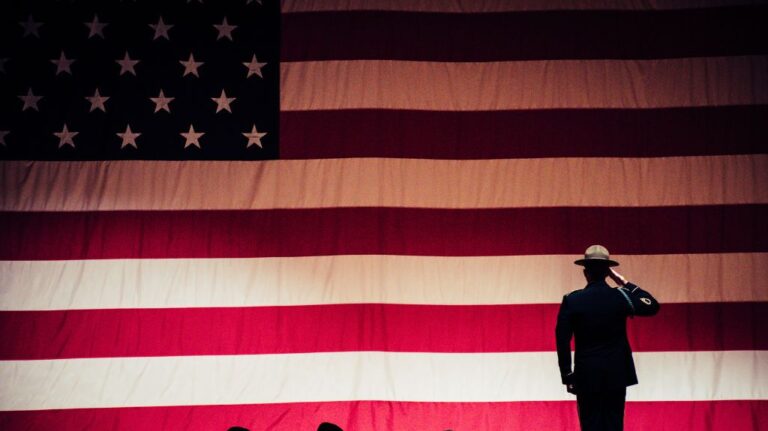 Drill Sergeant Standing in Front of American Flag Saluting