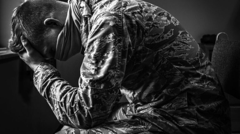 Black and White Photo of Veteran with His Head in His Hands with Depression
