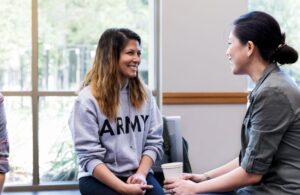 Female Veteran in Army Sweatshirt Speaking with Another Woman