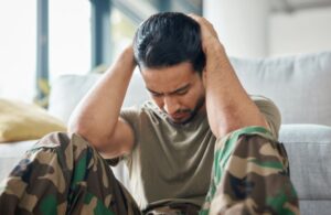 Veteran Sitting Against a Couch with Head in Hands