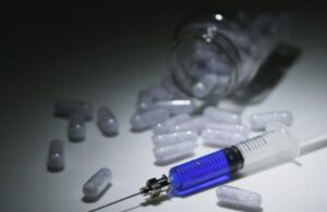 Pills and a Syringe on a Table