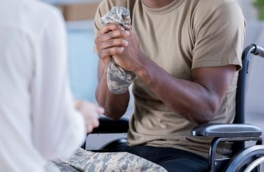 Veteran Sitting in Wheelchair and Talking to a Doctor