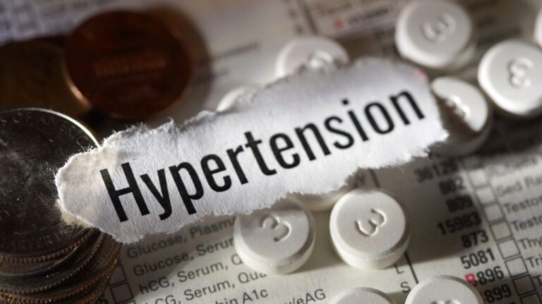 Paper with Hypertension Text with Pills and Coins