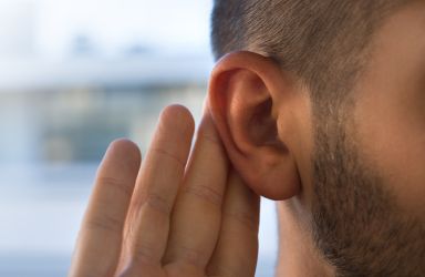 Man with Hand by Ear Indicating He Cannot Hear