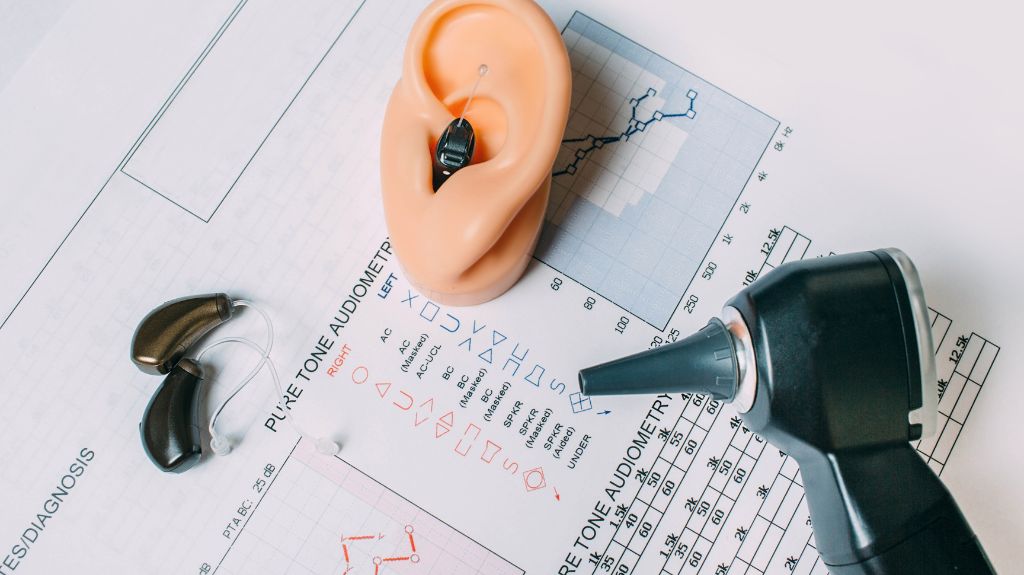 Ear Testing Documents and Hearing Aids on a Table