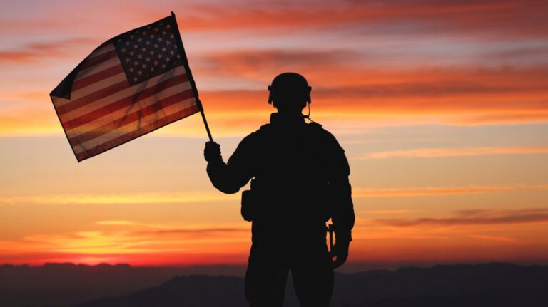 Veteran Holding American Flag at Sunset