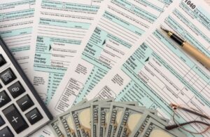 Tax Documents, Cash, and Calculator on a Table