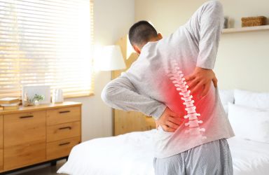 Man in Hospital Room Flexing Back with Red on Spine Graphic