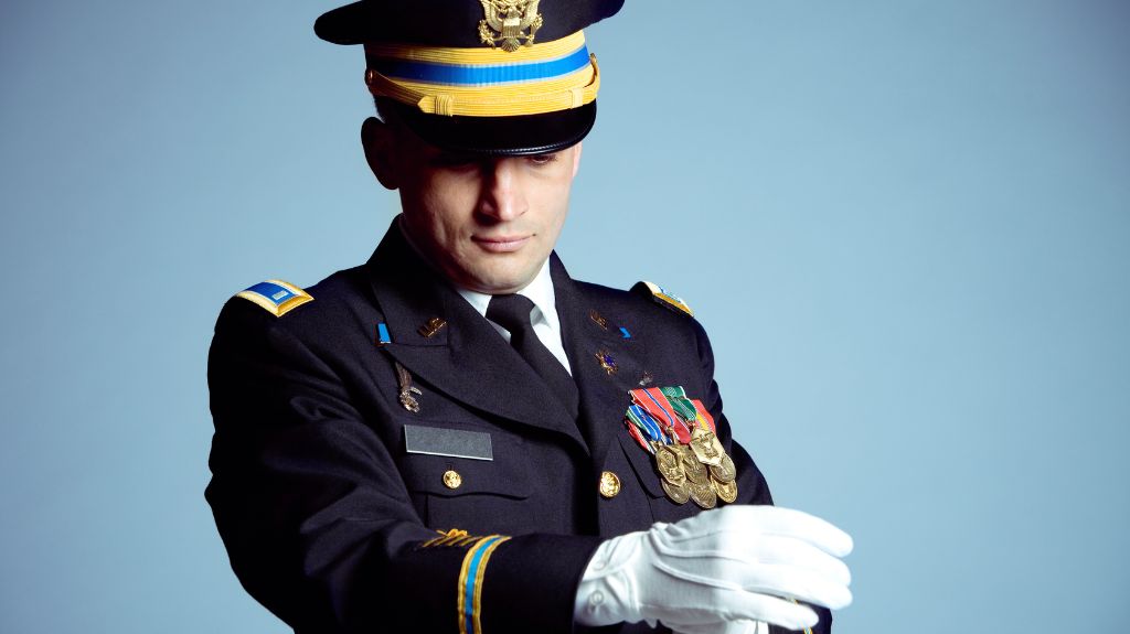 Army Soldier in Dress Uniform in Front of Blue Background