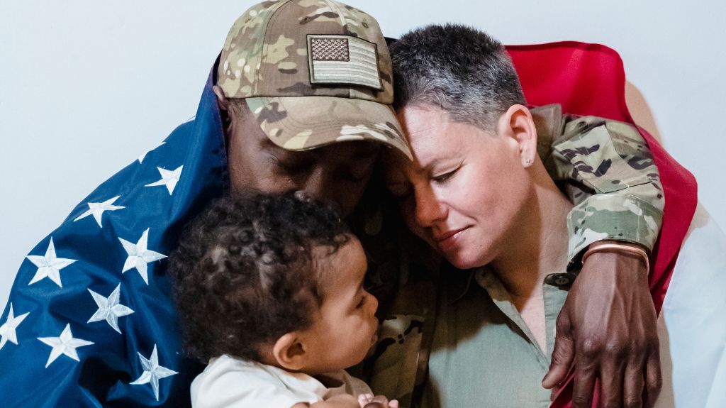 Veteran Wrapped in Flag Hugging Family