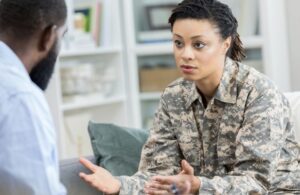 Female Veteran in Camouflage Speaking with Doctor