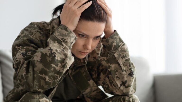 Female Veteran in Camouflage with Her Head in Her Hands