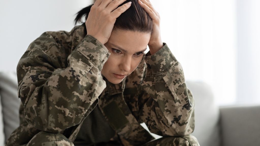 Female Veteran in Camouflage with Her Head in Her Hands