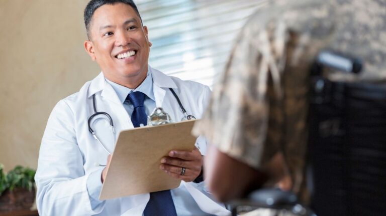 Veteran in Wheelchair Talking to Doctor with Clipboard